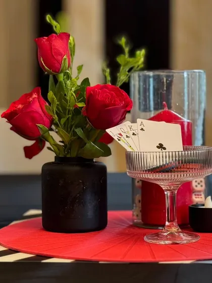 It's all in the details. For a casino-themed party, we designed these intricate table centerpieces, combining fresh red roses with playful elements like playing cards and dice. This close-up shows our commitment to carrying a theme through to the smallest touch, making the entire experience feel cohesive and thoughtfully crafted.