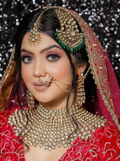 This bride wears a heavy, high-neck choker made of uncut Polki stones, paired with a unique side-jhumar (passa). This is a great option for a Muslim or Nizami bridal look.