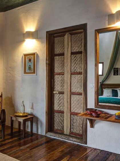 The interior of the Tower Room, showing the attention to detail in the custom furniture and the reflection of the canopy bed in the mirror.