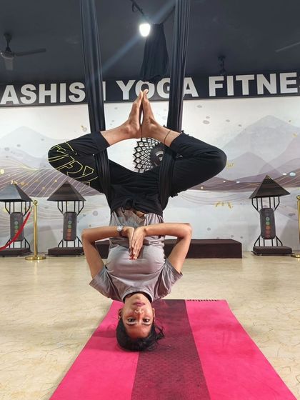 Finding stillness and balance while inverted in the silk hammock. This pose strengthens the core and improves focus, all while being fully supported.