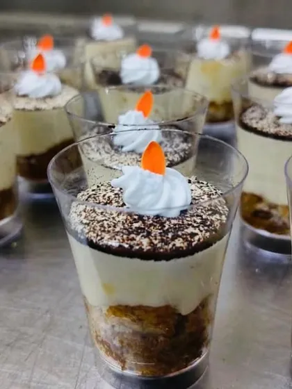 Shots anyone? Our Tiramisu is served in elegant shot glasses, layering coffee-soaked ladyfingers with creamy mascarpone.