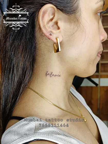 The word "balance" tattooed in a fine, delicate script on the neck. Placement is crucial for such visible tattoos, and we work with clients to find the perfect spot for their meaningful words.