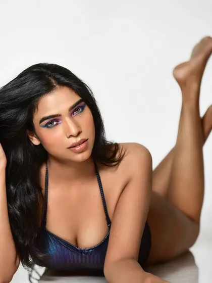The colorful eye makeup is shown as part of a full look with an iridescent bodysuit. The makeup complements the tones of the outfit, creating a cohesive and striking image.