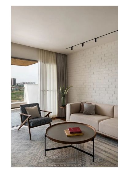 A corner of the living room, showing the comfortable seating and the connection to the balcony, which offers views of the nearby lake.