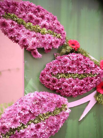 A close-up of a floral art installation. These shell-like structures are meticulously crafted from pink chrysanthemums, showcasing a unique and creative use of flowers in event decor.