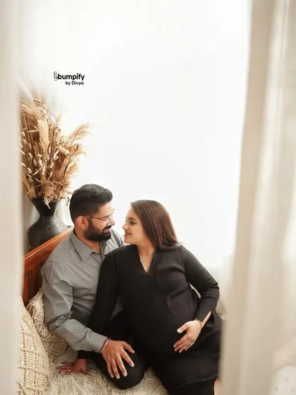 The couple shares a quiet moment on the bed. This setup is perfect for creating natural and lifestyle-oriented maternity photos right here in the studio.