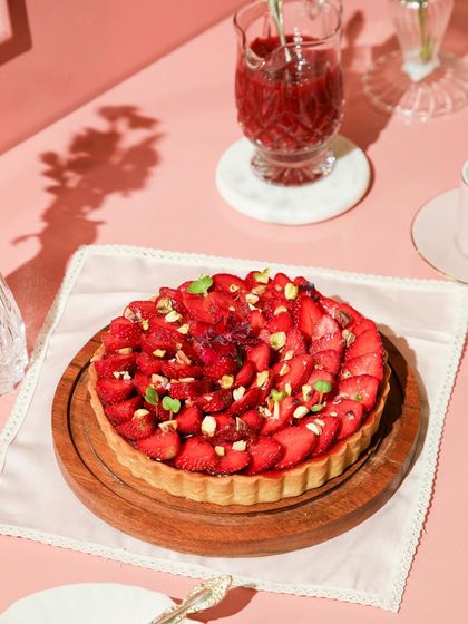 Another view of our strawberry tart, a delightful treat topped with pistachios and fresh herbs.
