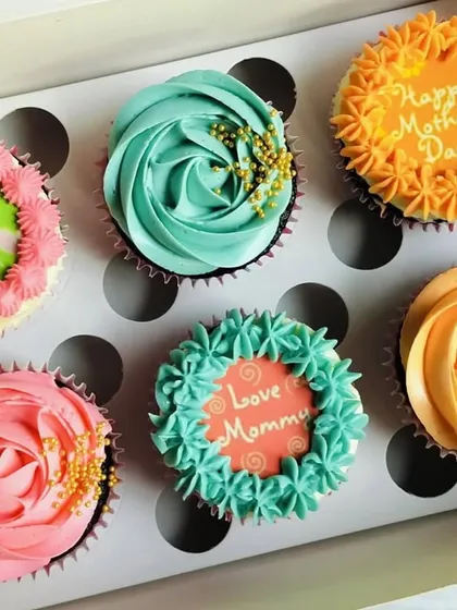 For Mother's Day, I created this colorful assortment box. It features a mix of designs, including edible toppers with "World's Best Mom" and beautiful buttercream roses in pink and orange, all sprinkled with gold for an elegant touch.