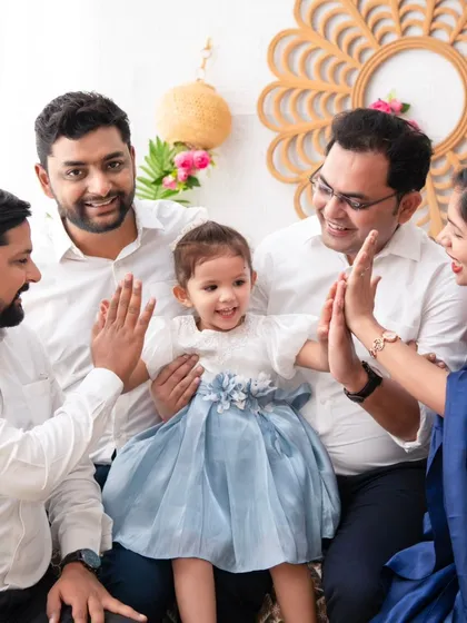 A family high-five. This photo captures a fun, interactive moment with the extended family, full of smiles and positive energy.