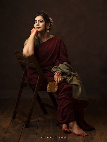 Holding a brass mirror, she looks thoughtful and poised. This portrait is a beautiful blend of tradition and fine art.