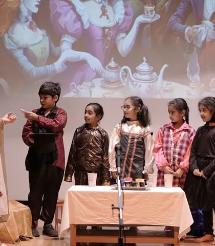 An ensemble scene from 'Alice in Wonderland' where multiple characters interact. This highlights our focus on group dynamics, ensuring every child understands their role within the larger story.