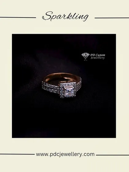 A sparkling princess-cut diamond engagement ring. The center stone is set on a band that is also encrusted with diamonds, creating a look of continuous brilliance.