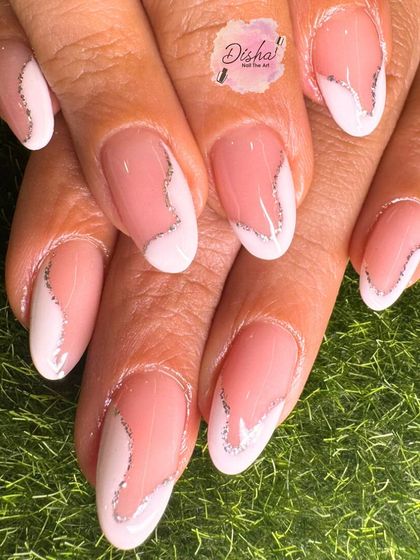 A modern take on the French manicure. This design features an abstract shape with a delicate silver glitter line for a chic and sophisticated look.