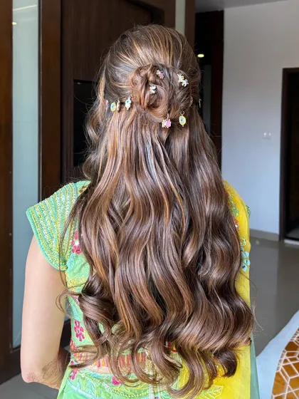 A close-up of the detailed Haldi hairstyle, showing the combination of a bun, twists, and colorful accessories.