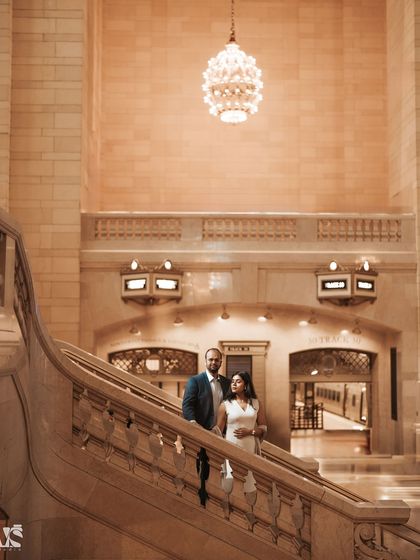 An elegant portrait of a couple on the grand staircase of Grand Central Station. The warm lighting and classic architecture give this photo a timeless, romantic quality.