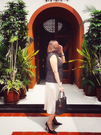 A side profile of my chic lunch outfit. The combination of the dark top and light skirt creates a beautiful contrast, showcasing a timeless and elegant style.