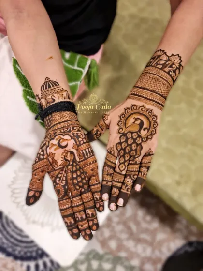 Another view of a beautiful Karwa Chauth mehendi. This angle highlights the graceful peacock on the back of the hand, surrounded by a sun-like halo, and a detailed wristband design.