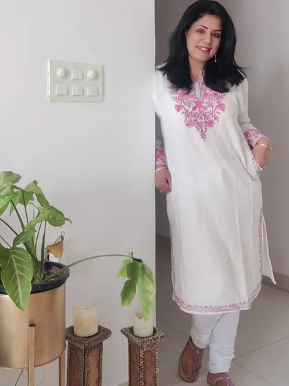 Here is the full look of the white pheran with white leggings and comfortable pink footwear. This is a great example of elegant and comfortable winter styling with Indian wear.