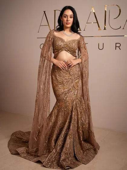A full shot of the client in a golden gown, her makeup looking simple, elegant, and perfect for the golden hour.