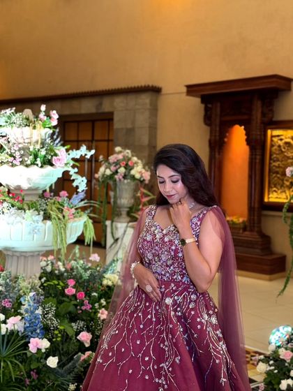 A gown that sparkles as much as your love. This wine-colored dress with silver embroidery is an elegant and romantic choice for an engagement party.