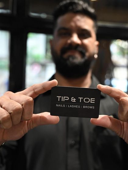 One of our proud team members holding up the Tip & Toe card.