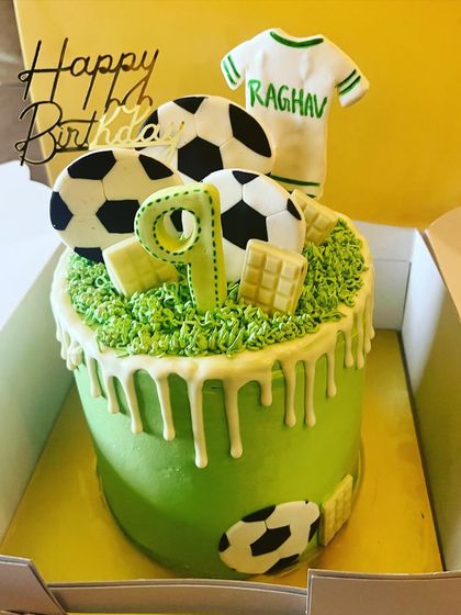Another goal-worthy football cake. This one has a bright green field, a white chocolate drip, and is topped with fondant soccer balls and a personalized jersey for the birthday boy.