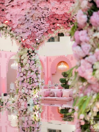 The 'Echoes of Pink' mandap reflected in the mirrored aisle. This design element amplified the beauty of the floral structure and the surrounding architecture, creating a surreal and magical effect.