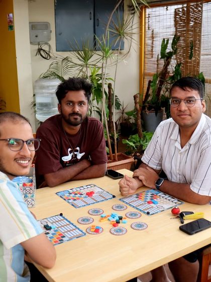 Three friends enjoy a game of 'Azul' on the terrace. The beautiful tiles of the game look even better in the natural light.
