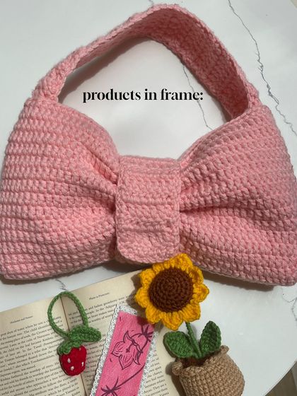 A flat lay showing the Bow Bag along with some of my other popular items like the strawberry bookmark and a mini sunflower pot.