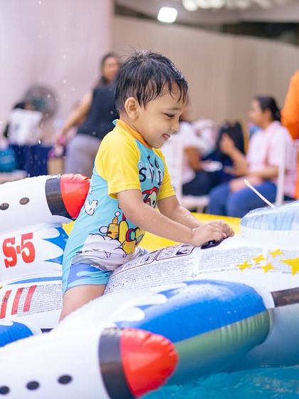 A happy boy rides a spaceship-themed float. I provide a variety of floats to spark the kids' imaginations, even within a single party theme.