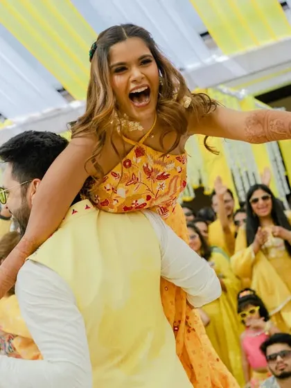 The groom lifts his bride in a joyful moment during their Haldi dance performance. A picture of pure happiness.