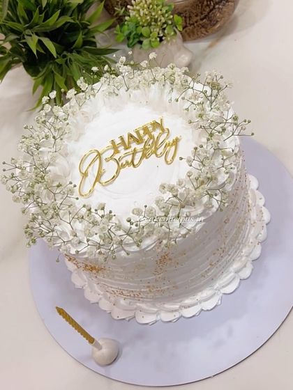 A simple and aesthetically pleasing white cake adorned with fresh baby's breath. This minimalist design is all about elegance and is perfect for any celebration where you want a touch of natural beauty.