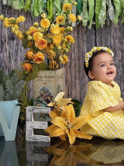 Surrounded by love and flowers. The bright yellow florals and "LOVE" sign make this a cheerful and heartwarming portrait.