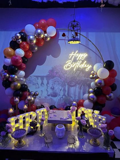 The full view of the balloon arch and table setup, perfect for a romantic and dramatic birthday surprise.