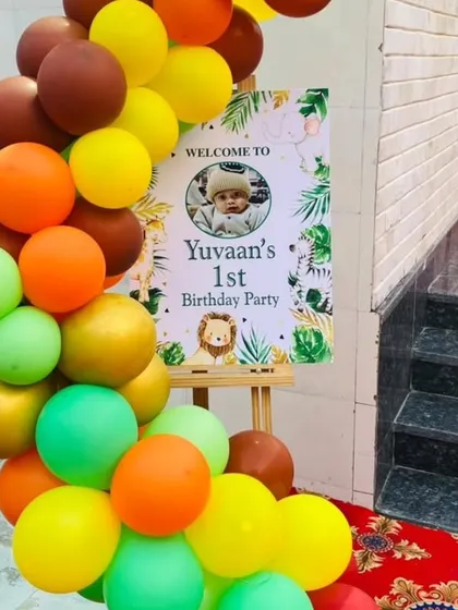 Welcome to the jungle party! This personalized welcome stand for "Yuvaan's 1st Birthday Party" is decorated with a jungle-themed balloon garland, setting the tone right from the entrance.