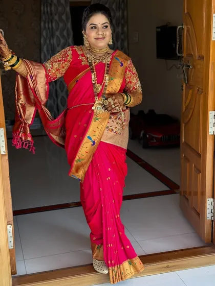A beautiful bride ready for her big day, dressed in a traditional pink Paithani saree with heavy gold jewellery.