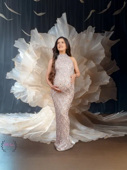 A glamorous portrait in a sparkling gown, set against a creative floral-inspired backdrop.