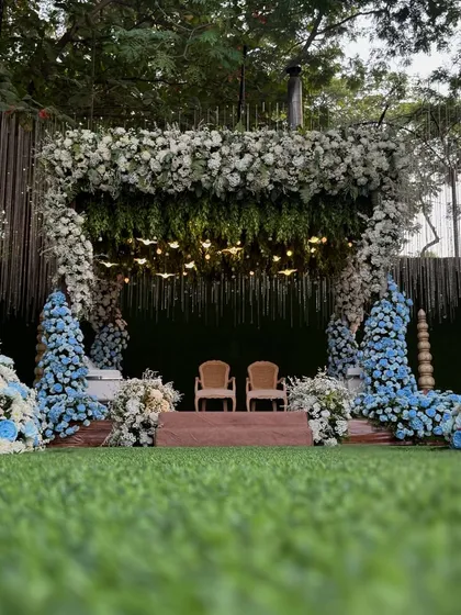 A unique and refreshing mandap design. We combined a canopy of white flowers with bold accents of blue, creating a striking and modern look for this outdoor wedding.