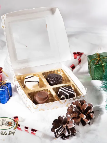 A smaller box of four assorted soft-centered chocolates, ideal for a small, elegant Christmas gift or as part of a larger hamper.