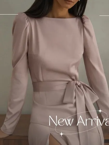 A detailed shot of the Enzo dress bodice and tie-waist, highlighting the soft puff sleeves and the quality of the satin.