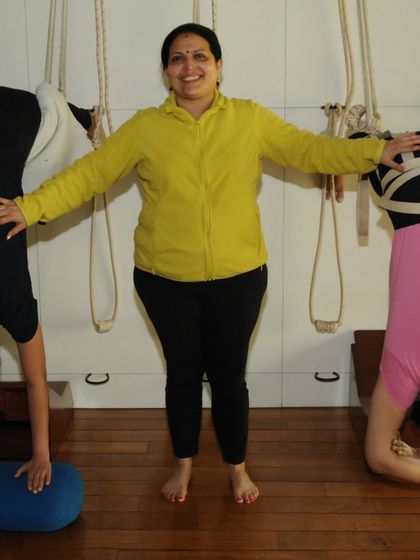 Two students in supported headstands using the wall ropes. This demonstrates how we can make advanced poses accessible and safe for different body types, allowing everyone to experience their benefits.