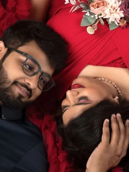 The love and anticipation are beautifully captured in this intimate overhead shot of the expecting couple. The rich red provides a passionate backdrop for their story.
