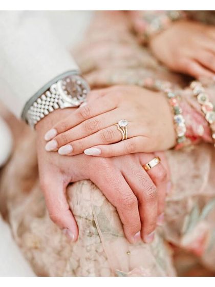 A close-up of hands, showcasing the engagement ring and wedding band. This symbolizes the commitment of two imperfect people dedicated to making their relationship work.