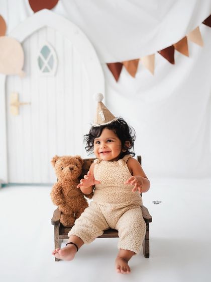 A happy birthday boy in his teddy bear themed first birthday shoot.