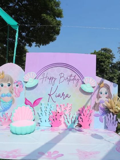The main stage decoration for the mermaid-themed party, featuring a 'Happy Birthday Kiara' backdrop and cute sea-themed cutouts.