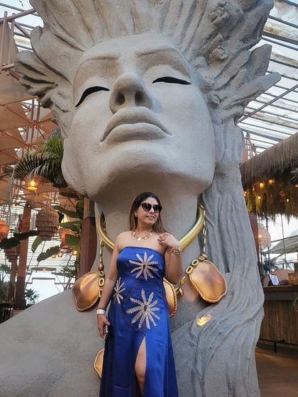 The same blue vacation dress, looking stunning against this artistic backdrop. It's all about creating outfits that make you feel like you're on a holiday.