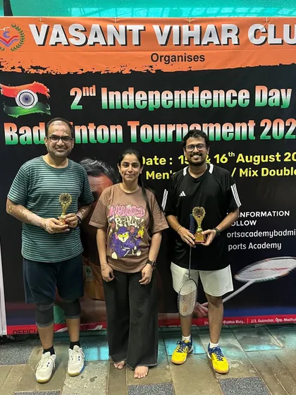 Participants proudly posing with their trophies in front of the tournament banner.