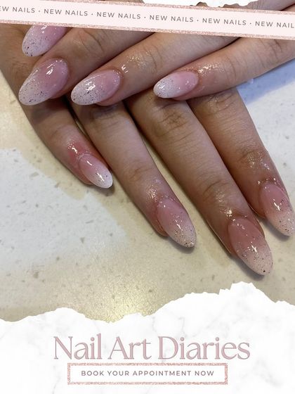 This is a beautiful example of a glitter ombre. The design transitions from a natural nude base to a sparkling silver tip, offering a glamorous take on the classic ombre style.