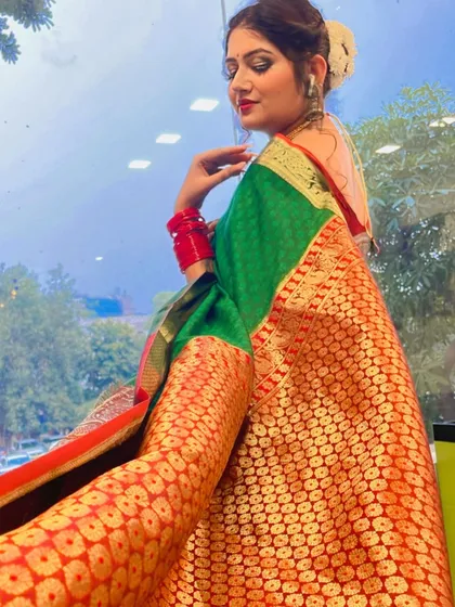 This photo shows the complete festive look, with traditional makeup and a classic hair bun adorned with a gajra. The entire look is coordinated to match her beautiful green and red banarasi saree.
