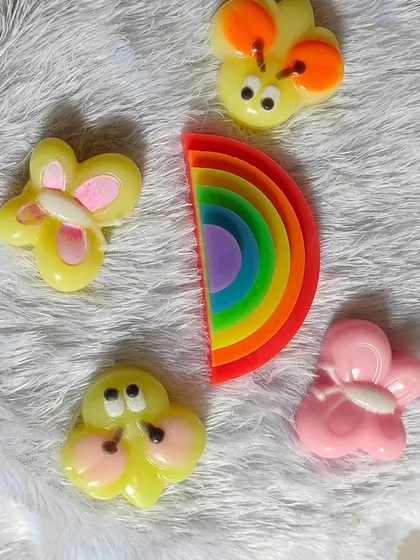 A collection of monsoon-themed soaps, including a rainbow, butterflies, and honey bees.